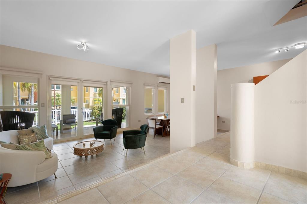 A bright living room features tile floors, a central pillar, and glass doors to a patio — 90 CANDELERO DRIVE UNIT 78, HUMACAO, PR