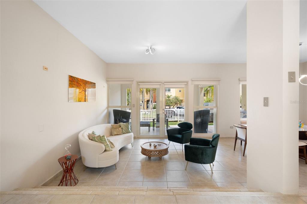 A living room features a curved white sofa, two dark armchairs, and glass patio doors — 90 CANDELERO DRIVE UNIT 78, HUMACAO, PR