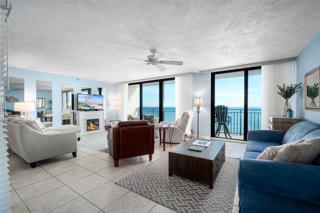 A living room with tile floors, a fireplace, and a balcony overlooking the ocean — 4139 S ATLANTIC AVENUE UNIT B508, NEW SMYRNA BEACH, FL