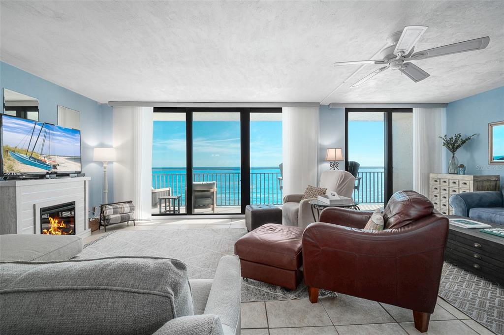 A living room features a fireplace, leather armchair, and large sliding doors overlooking the ocean — 4139 S ATLANTIC AVENUE UNIT B508, NEW SMYRNA BEACH, FL