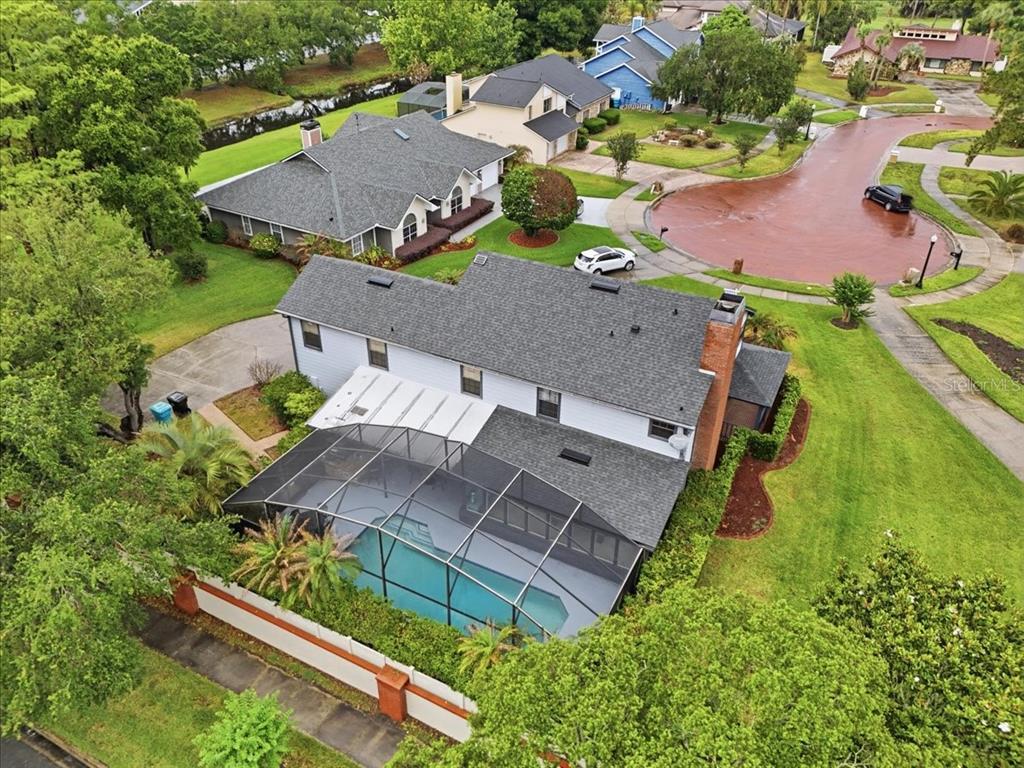 An aerial view of a two-story house with a screened-in pool and brick chimney — 4498 REAL COURT, ORLANDO, FL