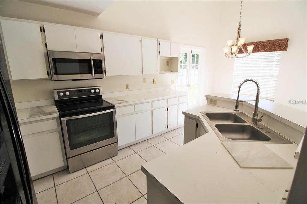 A kitchen with white cabinets, stainless steel appliances, tile flooring, and a double-basin sink — 1309 BLACK WILLOW TRAIL, ALTAMONTE SPRINGS, FL