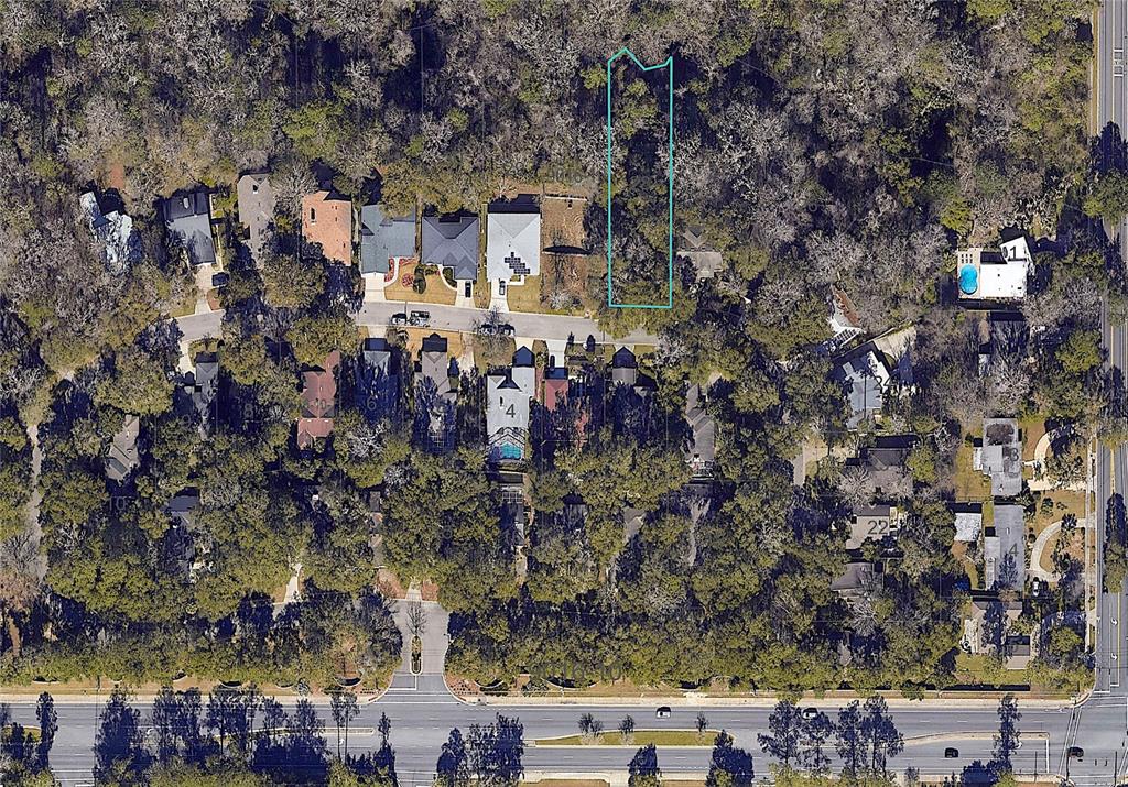 An aerial view shows a wooded residential lot outlined in blue within a suburban neighborhood — 1710 NW 17TH LANE, GAINESVILLE, FL
