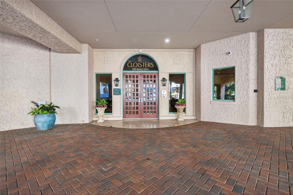 The exterior entrance features a brick driveway leading to double glass doors under a canopy — 288 BEACH DRIVE NE UNIT 4B, ST PETERSBURG, FL