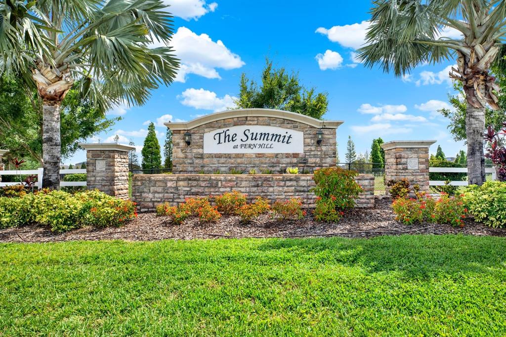 A stone monument sign for The Summit at Fern Hill stands amidst landscaping and palms — 10109 CRESTED FRINGE DRIVE, RIVERVIEW, FL