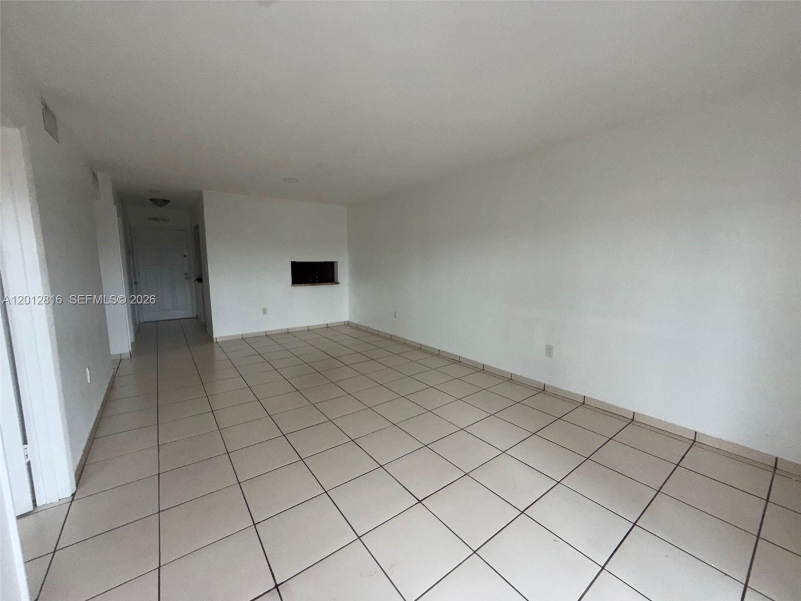 An empty room features white walls, light-colored tile flooring, and a small rectangular wall cutout — 120 Royal Palm Rd # 301, Hialeah Gardens FL 33016, HIALEAH GARDENS, FL