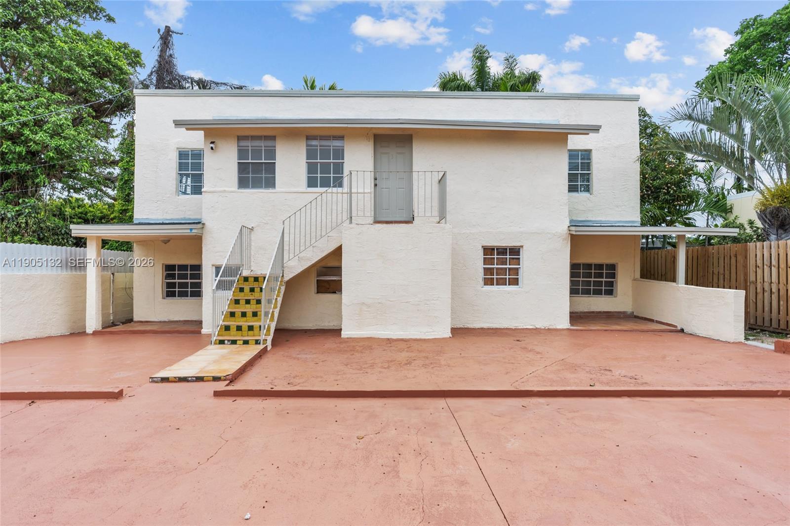 A two-story stucco building features an exterior staircase leading to an upper-level door — 2385 SW 17th St, Miami FL 33145, MIAMI, FL