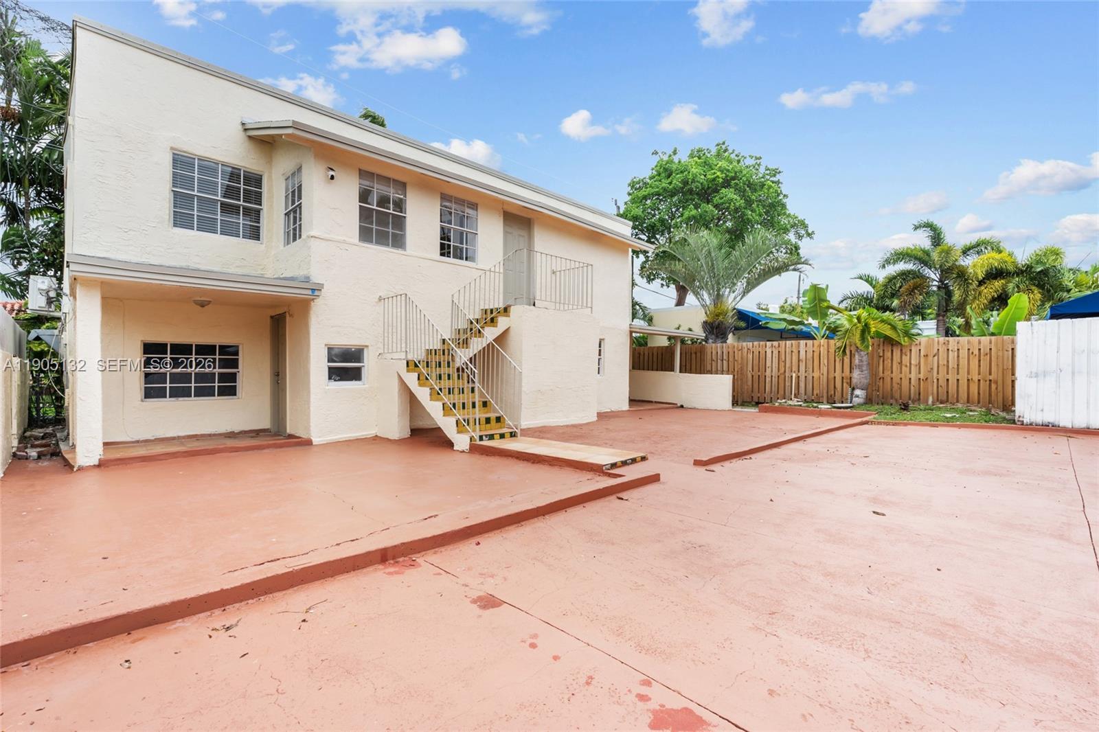 The exterior of a two-story stucco building features an outdoor staircase and a paved patio — 2385 SW 17th St, Miami FL 33145, MIAMI, FL