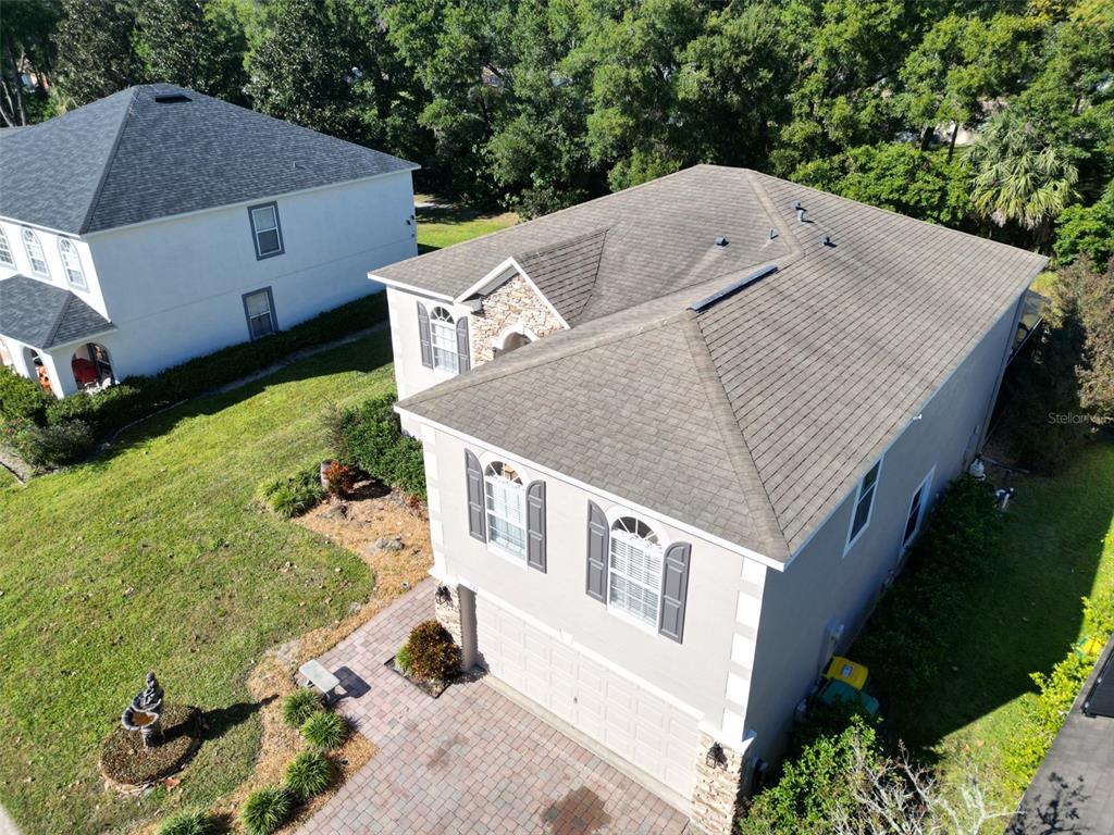 An aerial view shows the exterior of a two-story suburban house with a shingled roof — 121 W FIESTA KEY LOOP, DELAND, FL