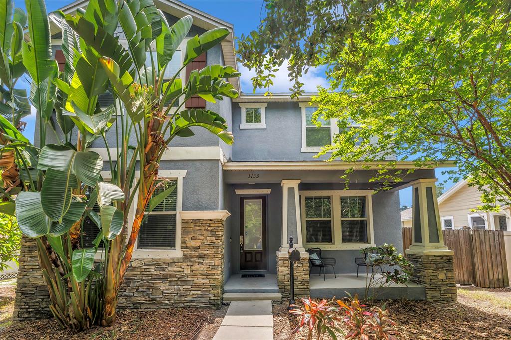 A two-story house with gray stucco, stone veneer, and a covered front porch — 1133 14TH STREET N, ST PETERSBURG, FL