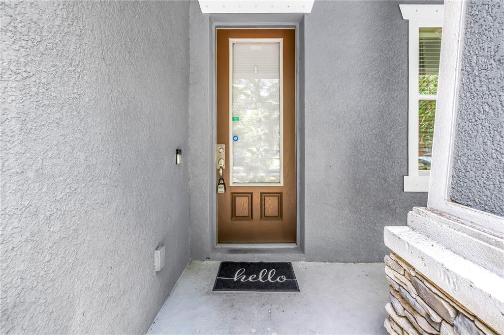 A front entryway features a brown door with a glass panel and a hello doormat — 1133 14TH STREET N, ST PETERSBURG, FL