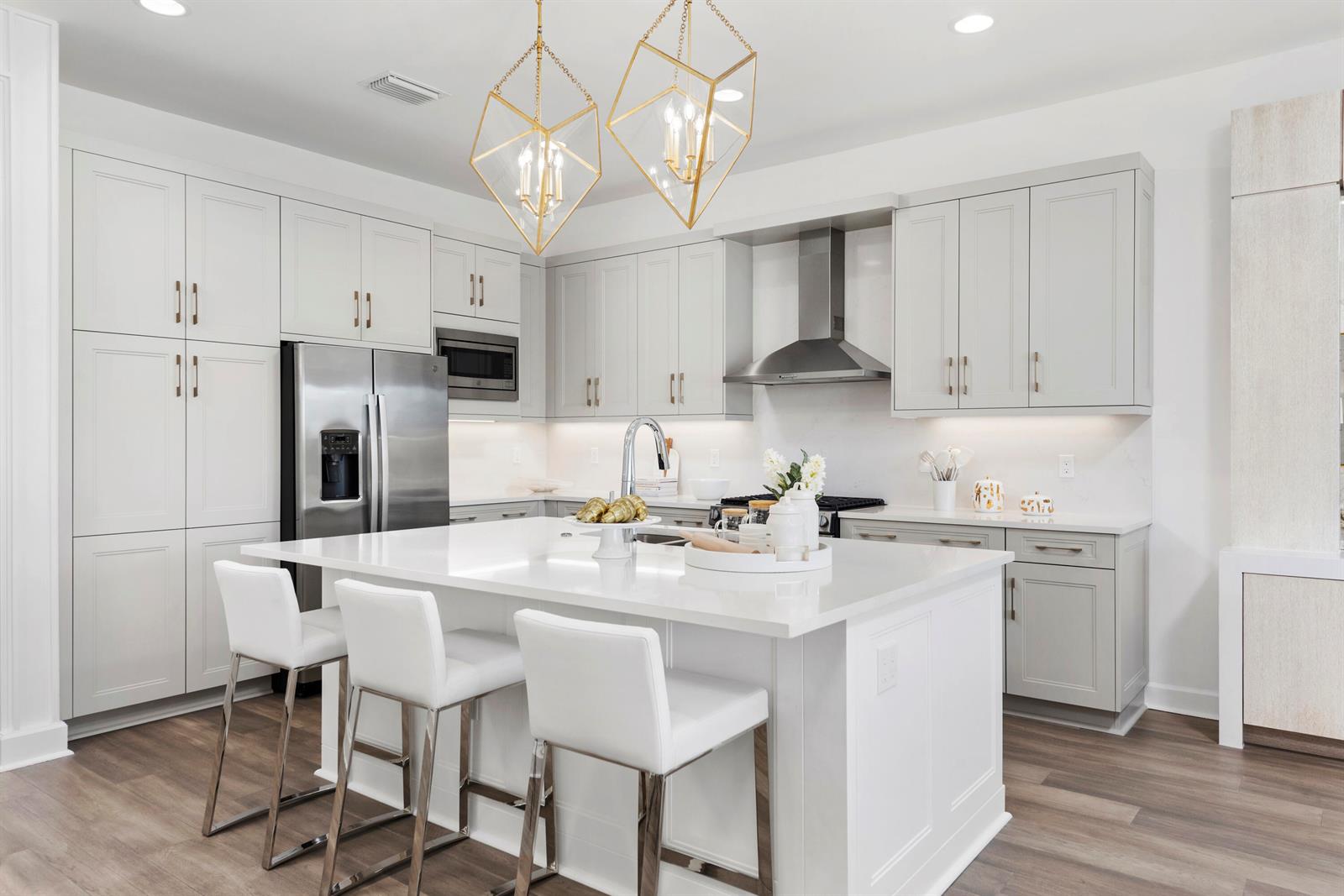A modern kitchen features light gray cabinets, a white quartz island, and gold geometric pendant lights — 481 40th Street, West Palm Beach FL 33407, WEST PALM BEACH, FL