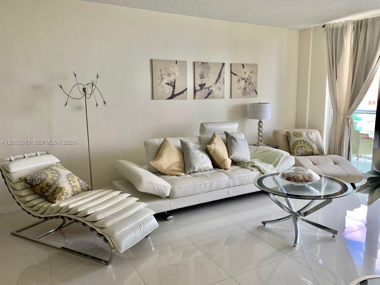 A living room features a white leather sofa, a chaise lounge, and a glass coffee table — 3901 S Ocean Dr # 10Z, Hollywood FL 33019, HOLLYWOOD, FL