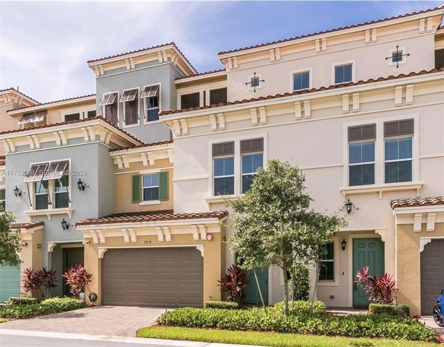 A multi-story townhouse exterior features a two-car garage, stucco walls, and a tiled roof — 2910 NW 124th Way # 2910, Sunrise FL 33323, SUNRISE, FL