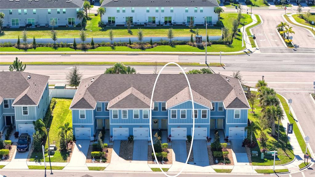 An aerial view shows a row of blue townhouses with a white oval highlighting two units — 14244 CRIMSON AVENUE, BRADENTON, FL