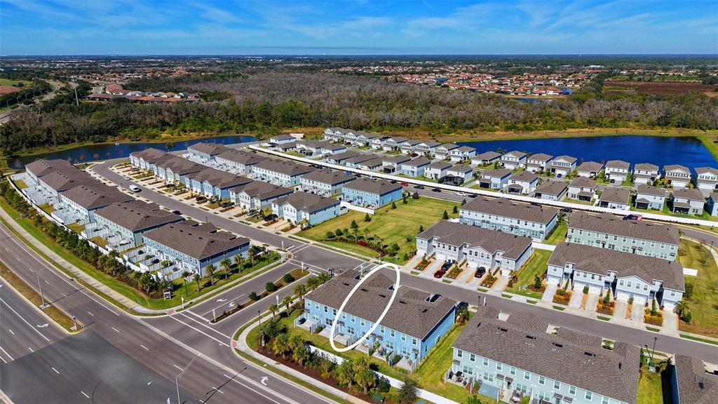 An aerial view shows a residential neighborhood of multi-story townhomes with a circled building — 14244 CRIMSON AVENUE, BRADENTON, FL