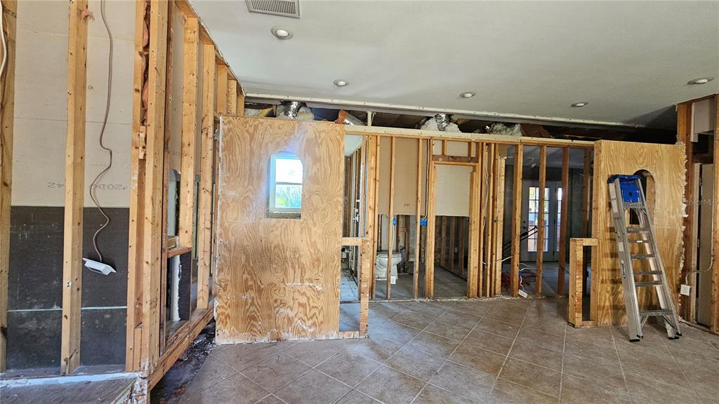 An interior view of a room under construction with exposed wooden wall studs and plywood — 208 48TH AVENUE N, ST PETERSBURG, FL