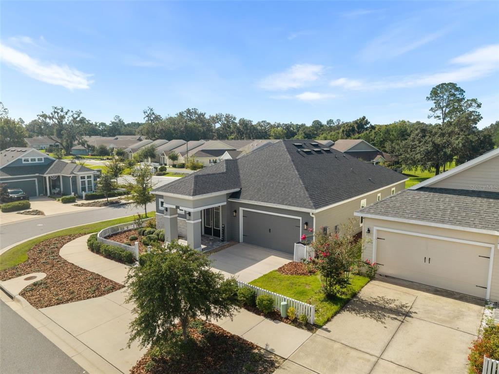 An aerial view shows a suburban house with a dark shingled roof and a screened-in patio — 1429 NW 132ND BOULEVARD, NEWBERRY, FL