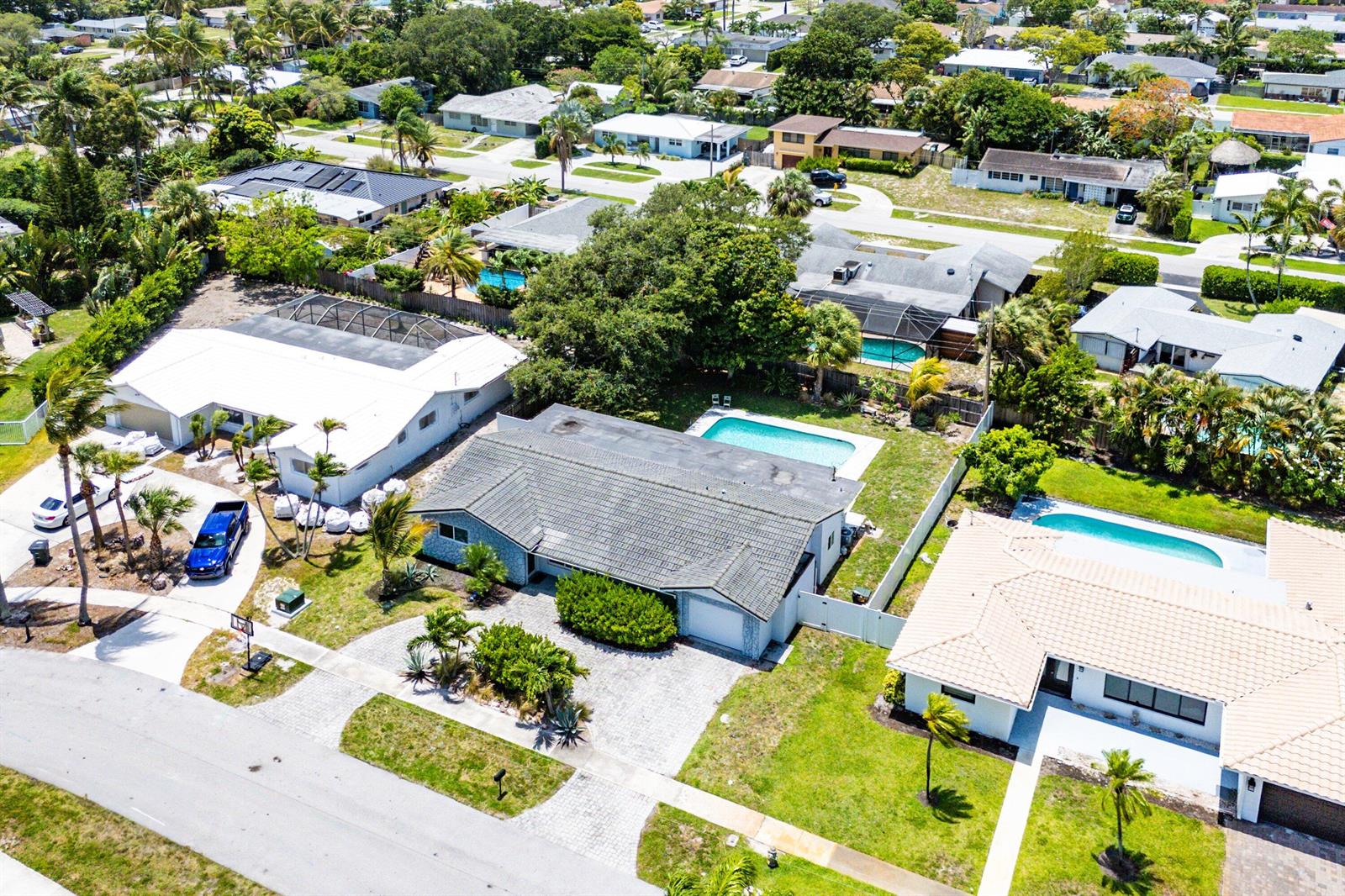An aerial view shows suburban houses with swimming pools and paved driveways in a neighborhood — 581 NW 13th Drive, Boca Raton FL 33486, BOCA RATON, FL