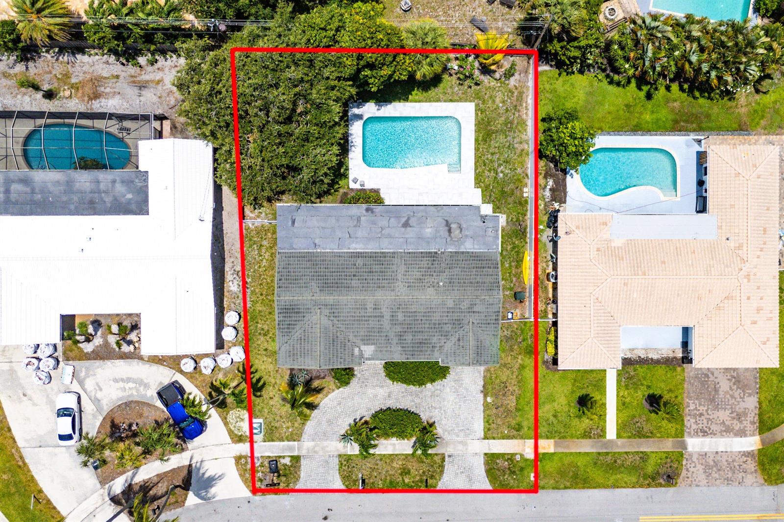 An aerial view shows a house with a pool, a paved driveway, and landscaping — 581 NW 13th Drive, Boca Raton FL 33486, BOCA RATON, FL