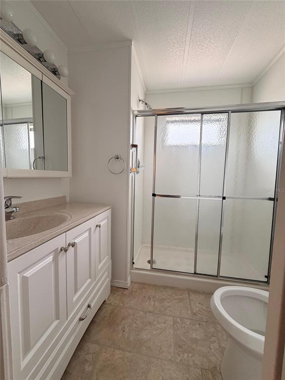 A bathroom features a white vanity, a glass-enclosed shower, and a toilet on tile flooring — 2514 17TH STREET LANE W, BRADENTON, FL