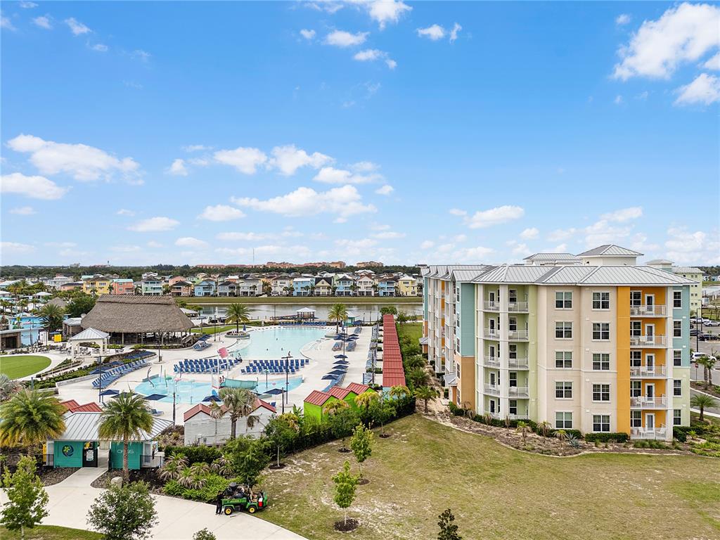 An aerial view shows a large apartment complex next to a swimming pool and clubhouse — 8061 VACATION AVENUE UNIT 213, KISSIMMEE, FL