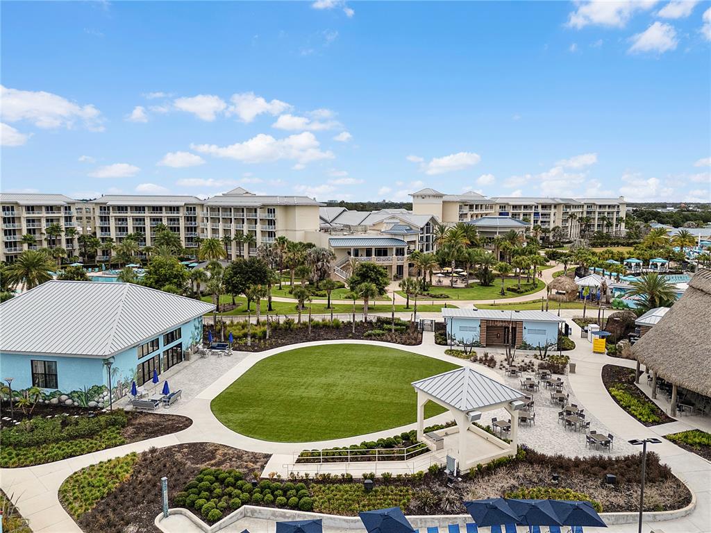 An aerial view shows a resort courtyard with a central lawn, buildings, and landscaping — 8061 VACATION AVENUE UNIT 213, KISSIMMEE, FL