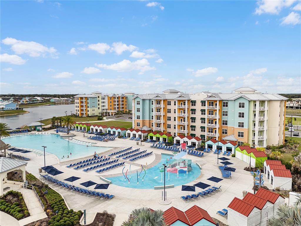 A large resort complex features a swimming pool, splash pad, and multi-story colorful buildings — 8061 VACATION AVENUE UNIT 213, KISSIMMEE, FL