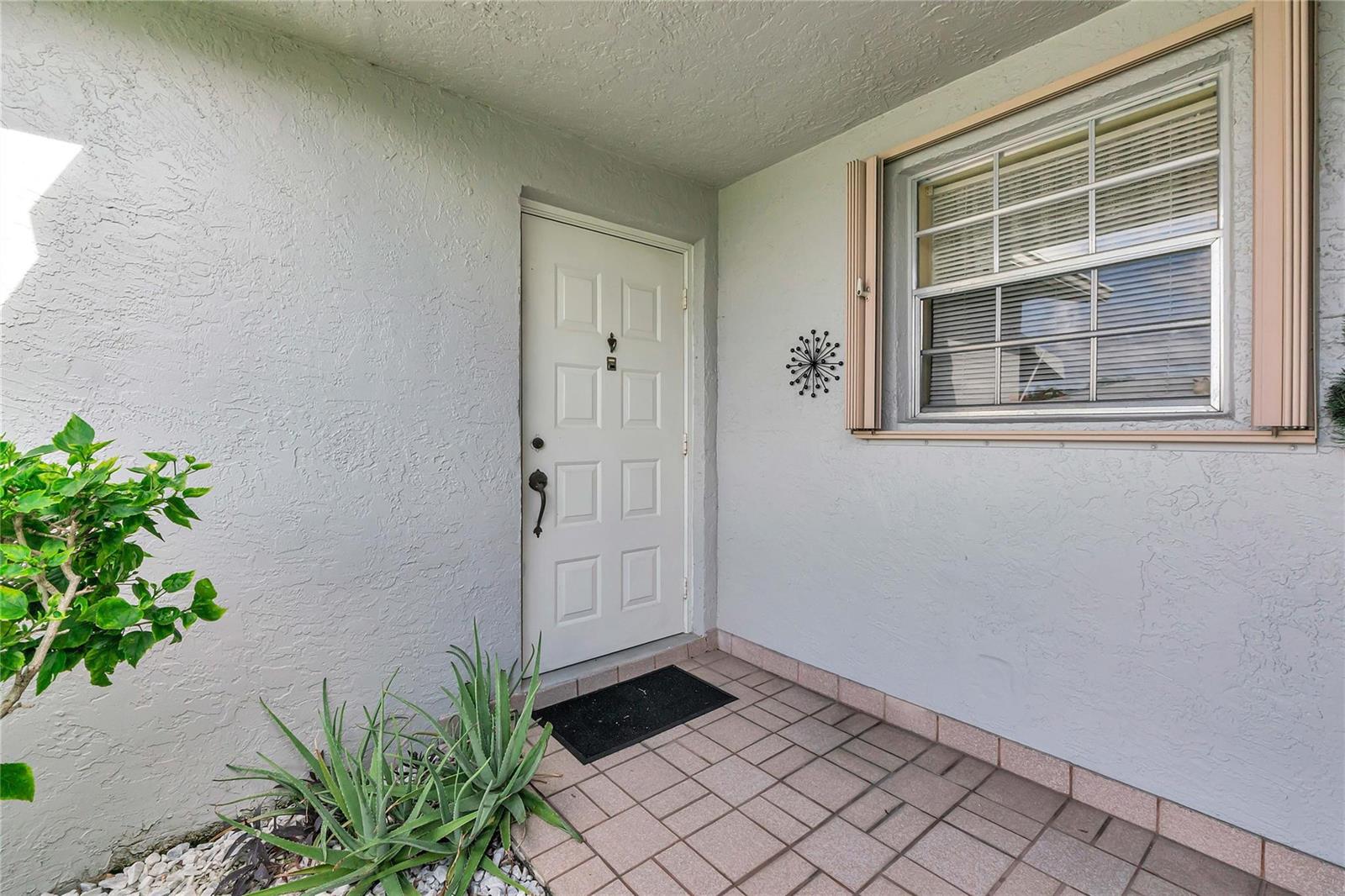 A white front door and a window with shutters are on the exterior porch — 14620 Canalview Drive # C, Delray Beach FL 33484, DELRAY BEACH, FL