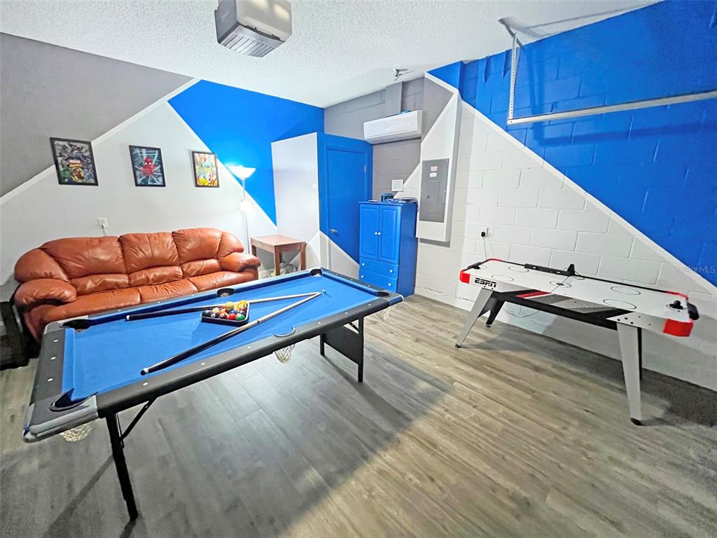 A game room features a pool table, air hockey table, brown sofa, and blue accents — 120 MADIERA BEACH BOULEVARD, KISSIMMEE, FL