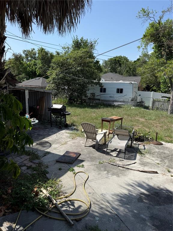 A backyard patio features a grill, outdoor furniture, and a parked travel trailer — 3012 N ALBANY AVENUE, TAMPA, FL