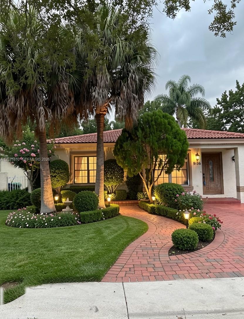 A single-story house features a brick walkway, manicured landscaping, and two tall palm trees — 9136 NW 192nd Ter, Hialeah FL 33018, HIALEAH, FL