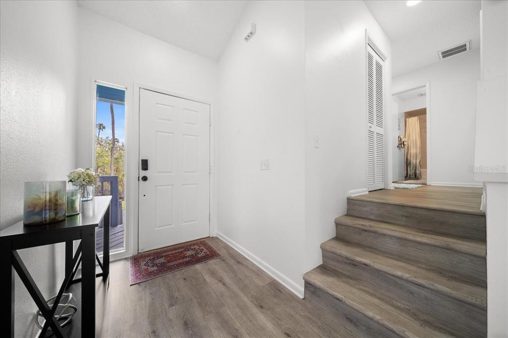 An entryway features a white front door, wood-look flooring, and stairs leading to a hallway — 2925 N RIVERS EDGE BOULEVARD UNIT 2925, CRYSTAL RIVER, FL