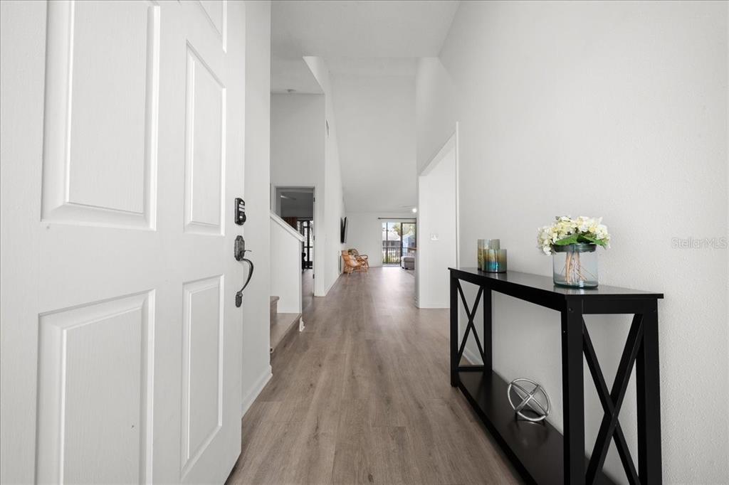 An entryway with light wood flooring leads into a bright, open-concept living space — 2925 N RIVERS EDGE BOULEVARD UNIT 2925, CRYSTAL RIVER, FL