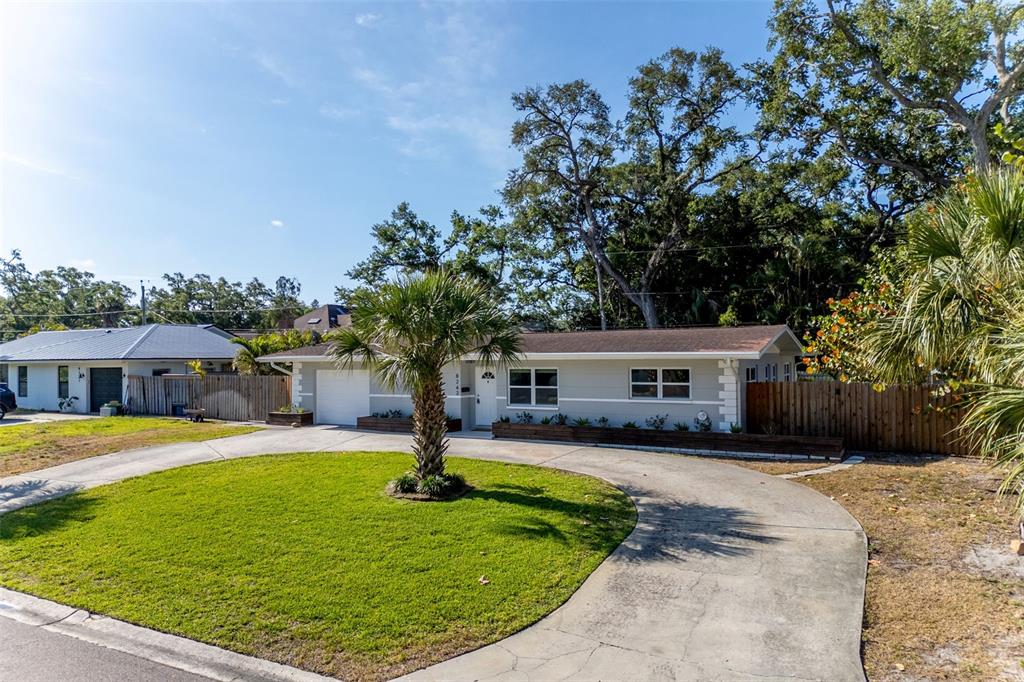 A single-story house with a gray exterior, a curved driveway, and a palm tree in front — 8242 31ST TERRACE N, ST PETERSBURG, FL
