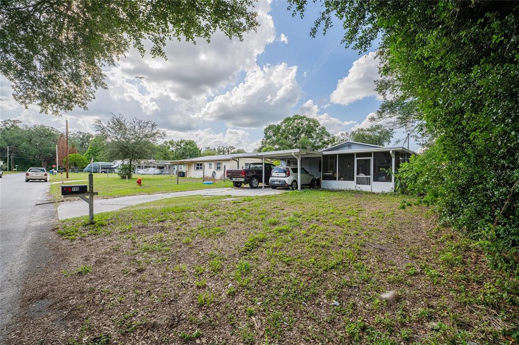 A single-story house with a carport and a screened porch sits on a grassy lot — 490 W ETHELENE STREET, BARTOW, FL