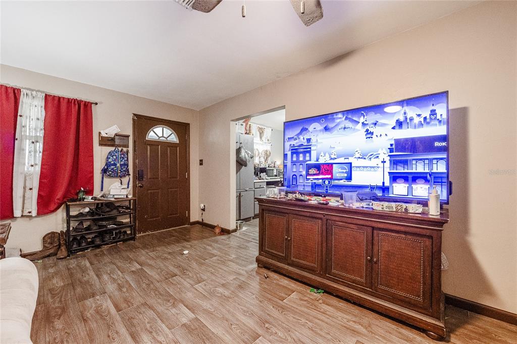 A living room features wood-look flooring, a large television on a wooden console, and an entryway — 490 W ETHELENE STREET, BARTOW, FL