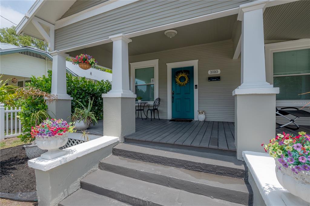 A front porch with gray steps, white columns, and a teal door with a wreath — 1010 E CURTIS STREET, TAMPA, FL