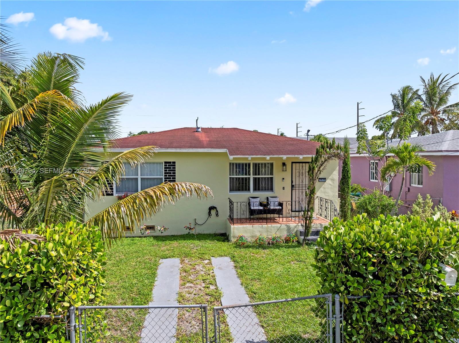A light yellow single-story house with a red roof and a small front porch — 1920 NW 69th Ter, Miami FL 33147, MIAMI, FL