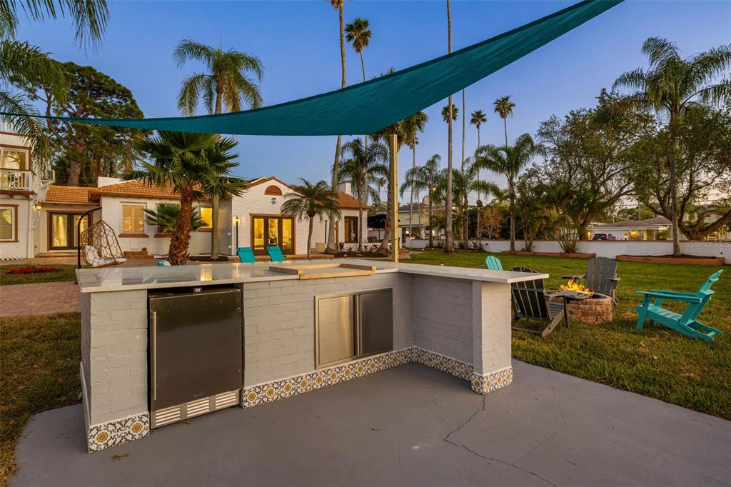 An outdoor kitchen with a brick base and tile accents sits on a concrete patio — 236 SAN SALVADOR DRIVE, DUNEDIN, FL