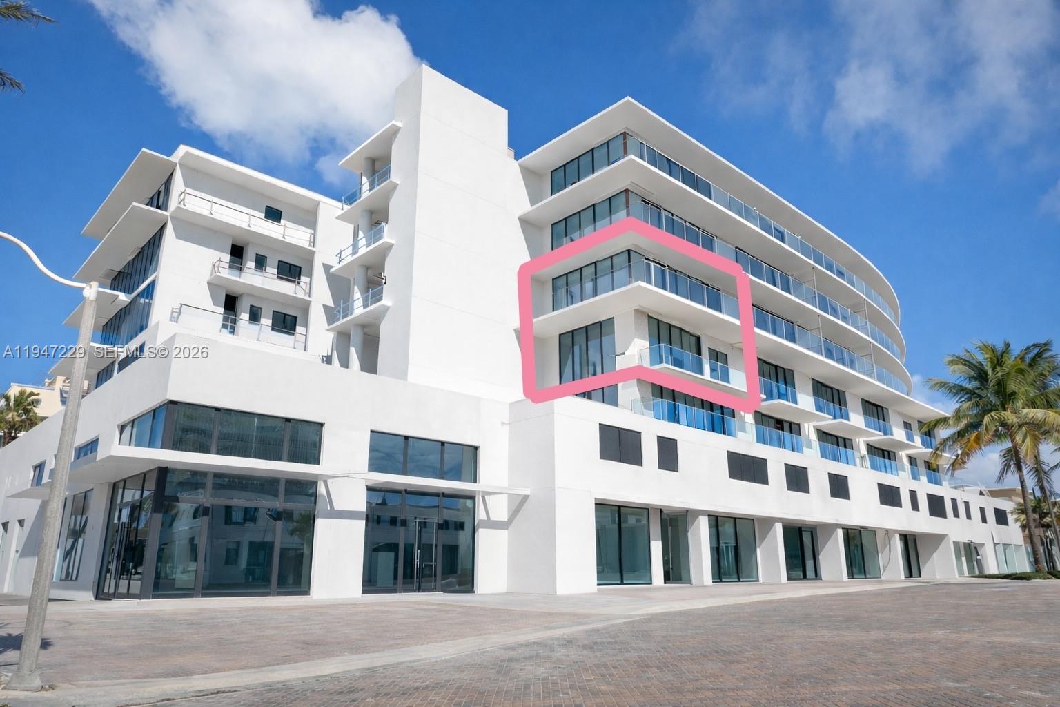 A modern white multi-story building features a highlighted corner balcony on the upper level — 3319 N Ocean Drive, Hollywood FL 33019, HOLLYWOOD, FL
