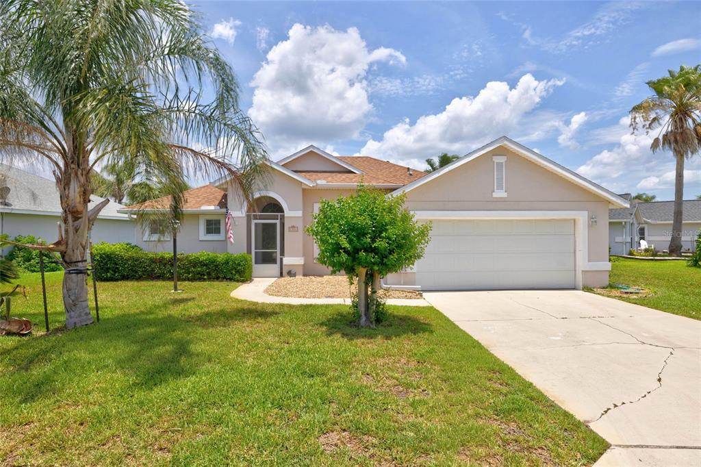 A single-story house with a beige stucco exterior, a two-car garage, and a palm tree — 1301 FLAGSHIP COURT, ST AUGUSTINE, FL