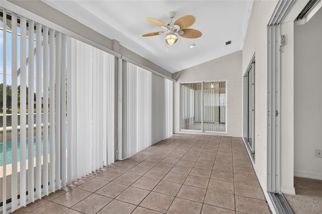 A tiled sunroom features vertical blinds, a ceiling fan, and sliding glass doors — 1301 FLAGSHIP COURT, ST AUGUSTINE, FL