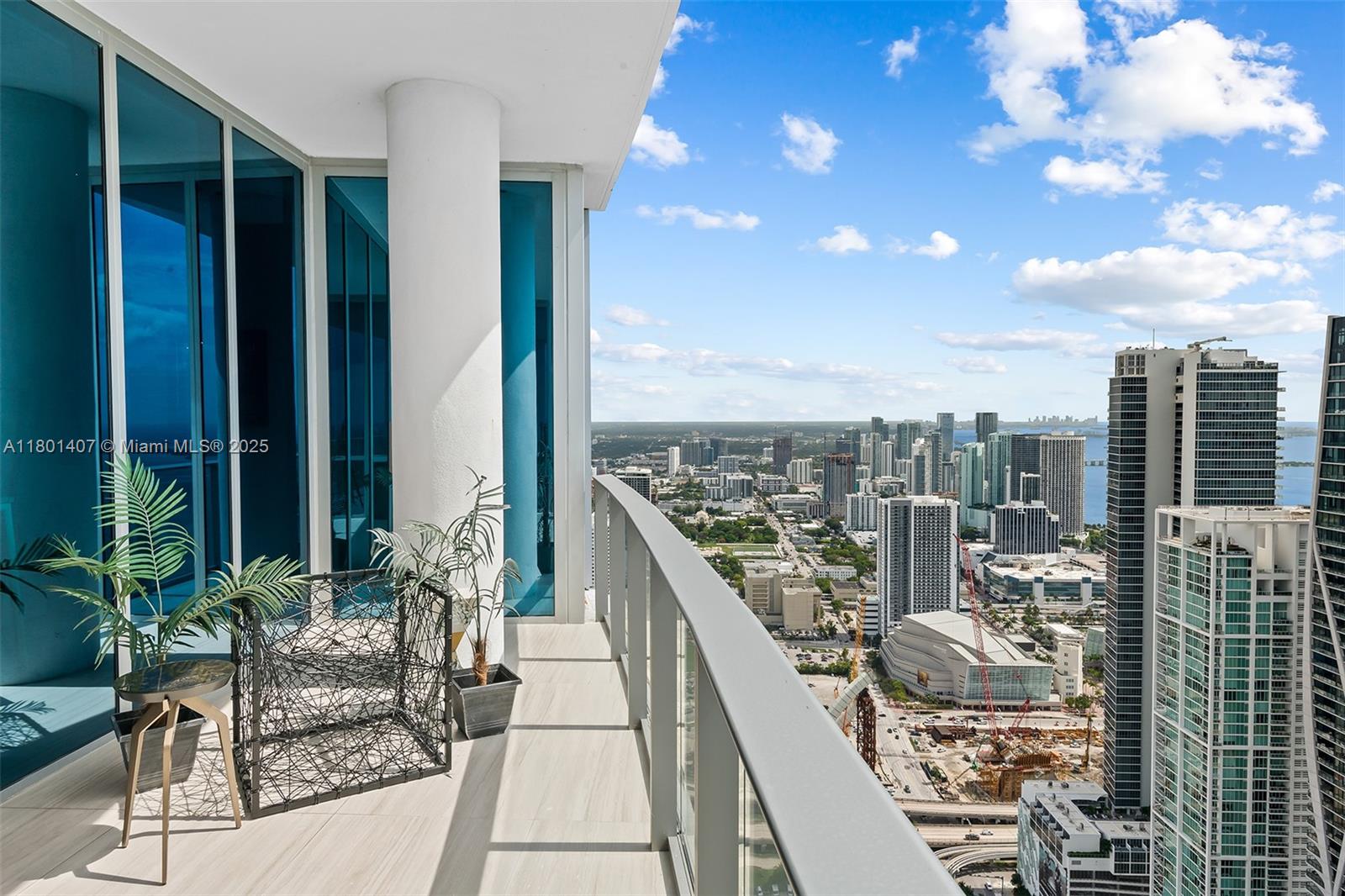 A high-rise balcony with glass railings overlooks a dense urban cityscape and the ocean — 851 NE 1st Ave # 5401, Miami FL 33132, MIAMI, FL