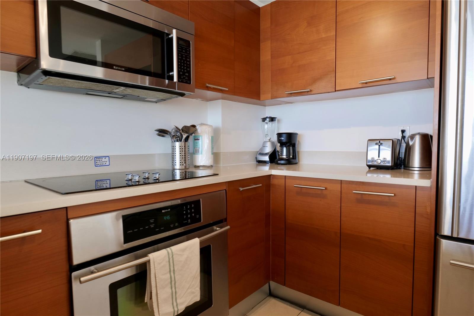 A kitchen features wood cabinets, stainless steel appliances, and white countertops — 3250 NE 1st Ave # 910, Miami FL 33137, MIAMI, FL