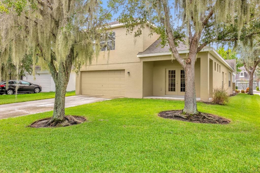 A two-story house with a tan stucco exterior, a two-car garage, and a covered entryway — 14217  BRIDGEWATER CROSSINGS BOULEVARD, WINDERMERE, FL