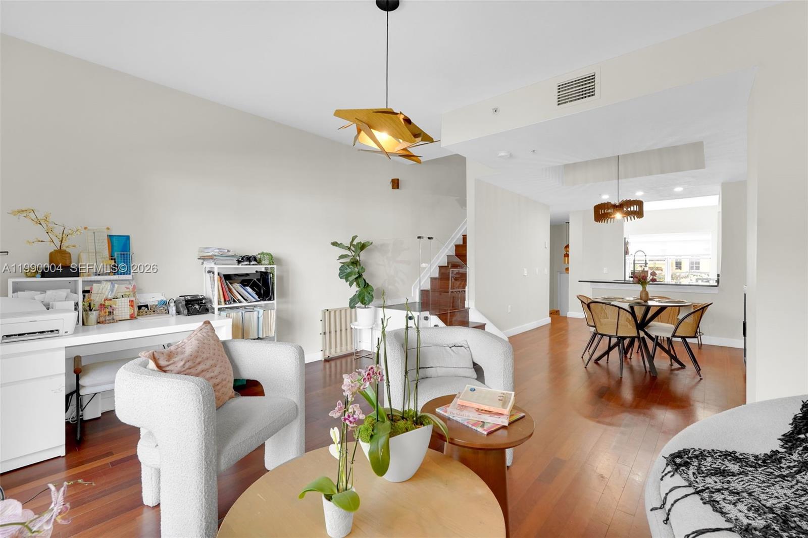 A kitchen features white cabinets, black countertops, stainless steel appliances, and light wood-look flooring — 738 NE 90th St # 207, Miami FL 33138, MIAMI, FL