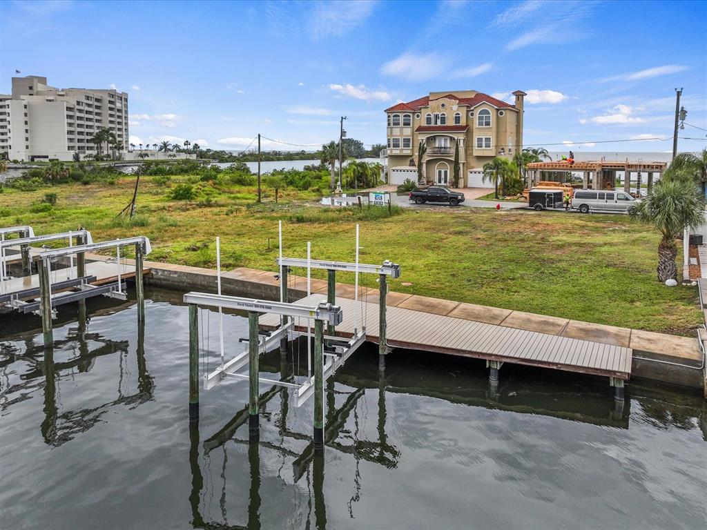 An aerial view shows a waterfront lot with a boat lift, dock, and nearby house — 6200 LONNIE LEE LANE, HUDSON, FL