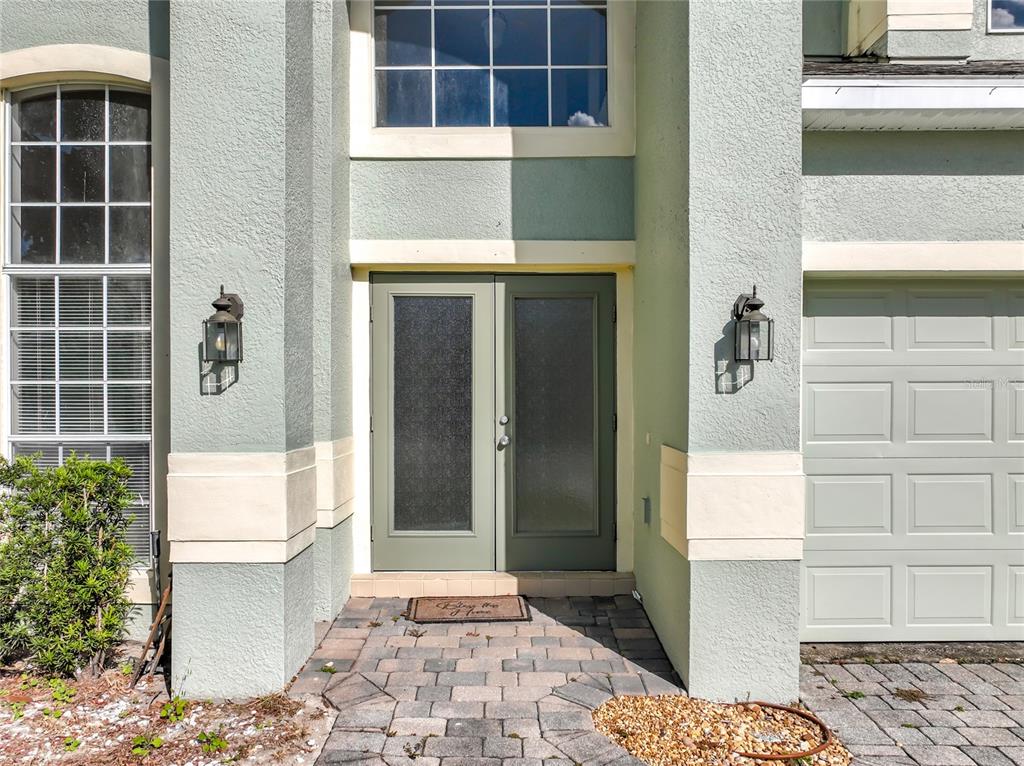 The exterior of a house features a double front door, a garage, and two windows — 33411 TERRAGONA DRIVE, SORRENTO, FL