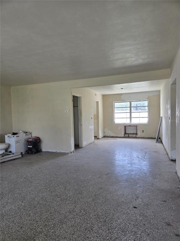 An interior view of a room with terrazzo flooring, beige walls, and a large window — 1216 FRANKLIN CIRCLE, CLEARWATER, FL